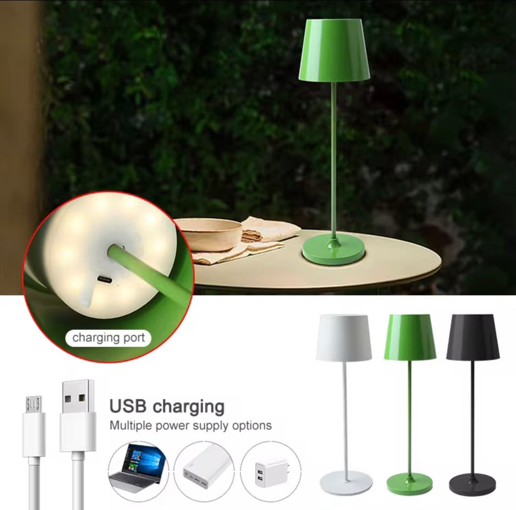 Green table lamp on a wooden surface with close-up of charging port and USB cable, surrounded by other lamps.