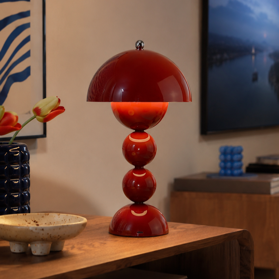 Red table lamp on a wooden surface with a blurred background